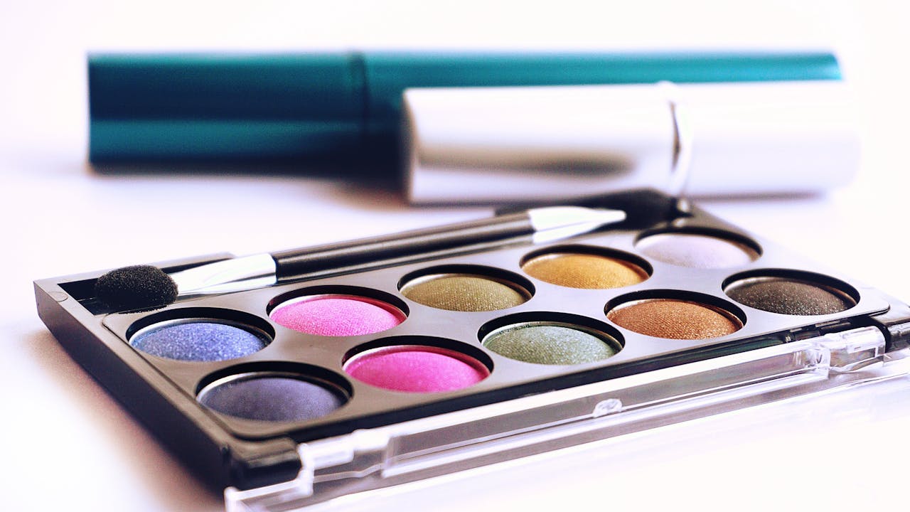 gallery-03 Close-up of colorful eyeshadow palette with brush, ideal for fashion and beauty themes.